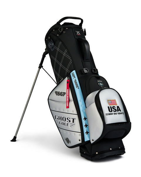 Front product shot of the Striker Anyday Bag standing on its integrated leg stand, featuring Ghost Golf branding and an embroidered USA flag on the front ball pocket. Clean product image highlighting the bag’s premium construction, functional stand design, patriotic detailing, and signature Ghost Golf styling.
