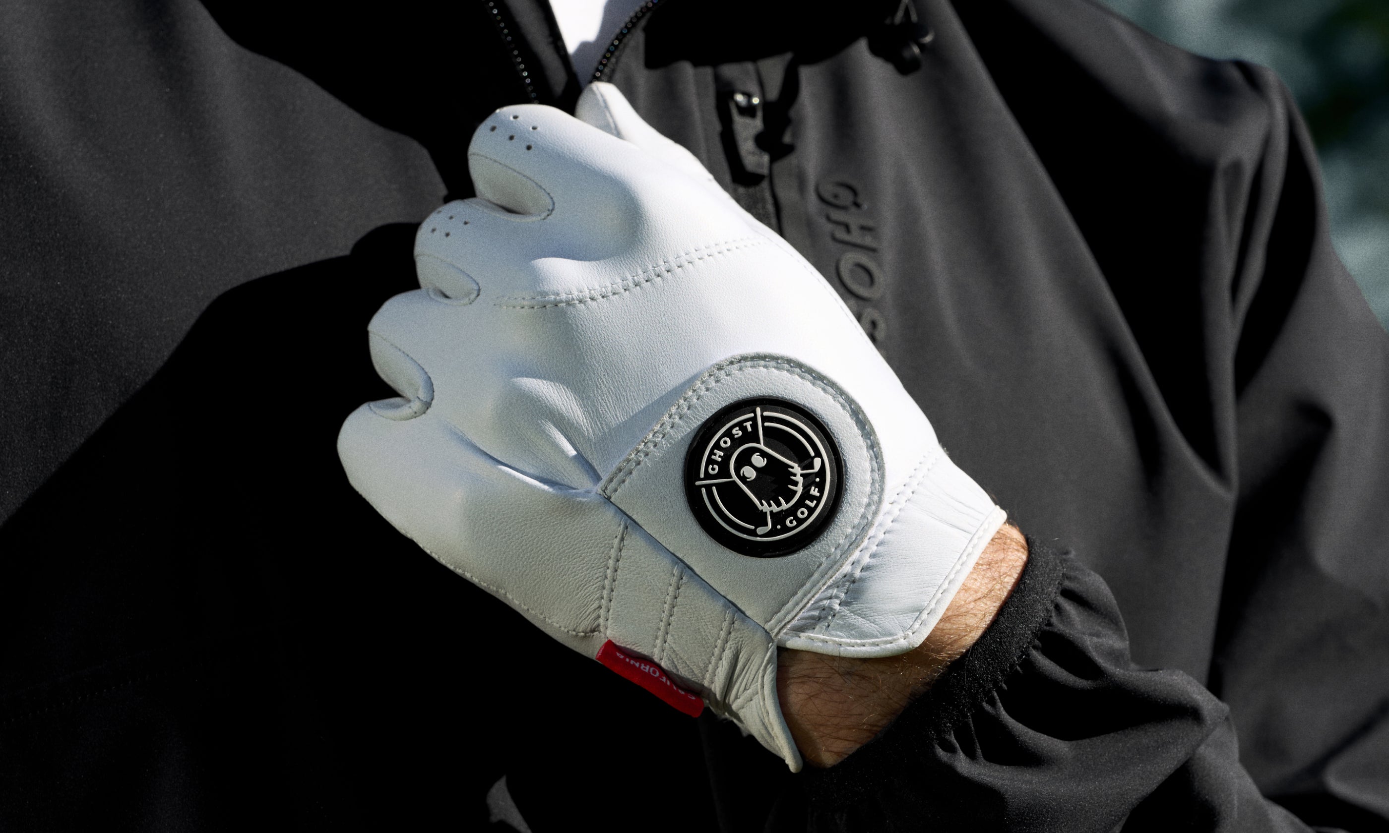 White golf glove with a Ghost Golf logo on a blurred background