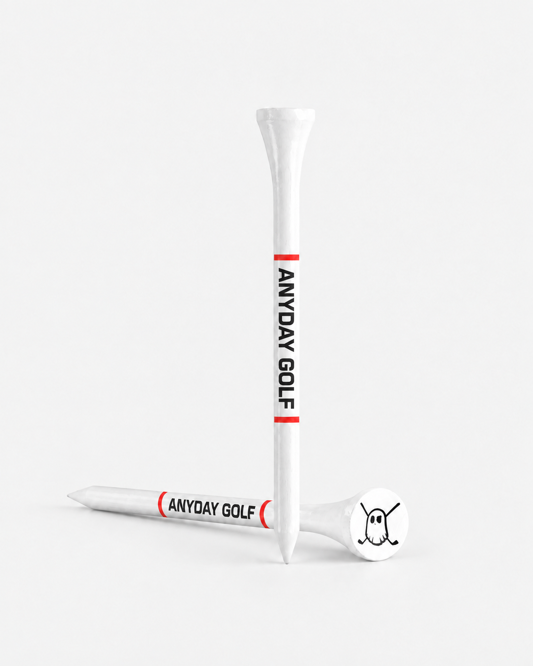 Two white tees with red bands and black 'ANYDAY GOLF' text, shown on a clean light gray studio background. One tee is upright and one lies on its side, with a white club head resting on the tee base.