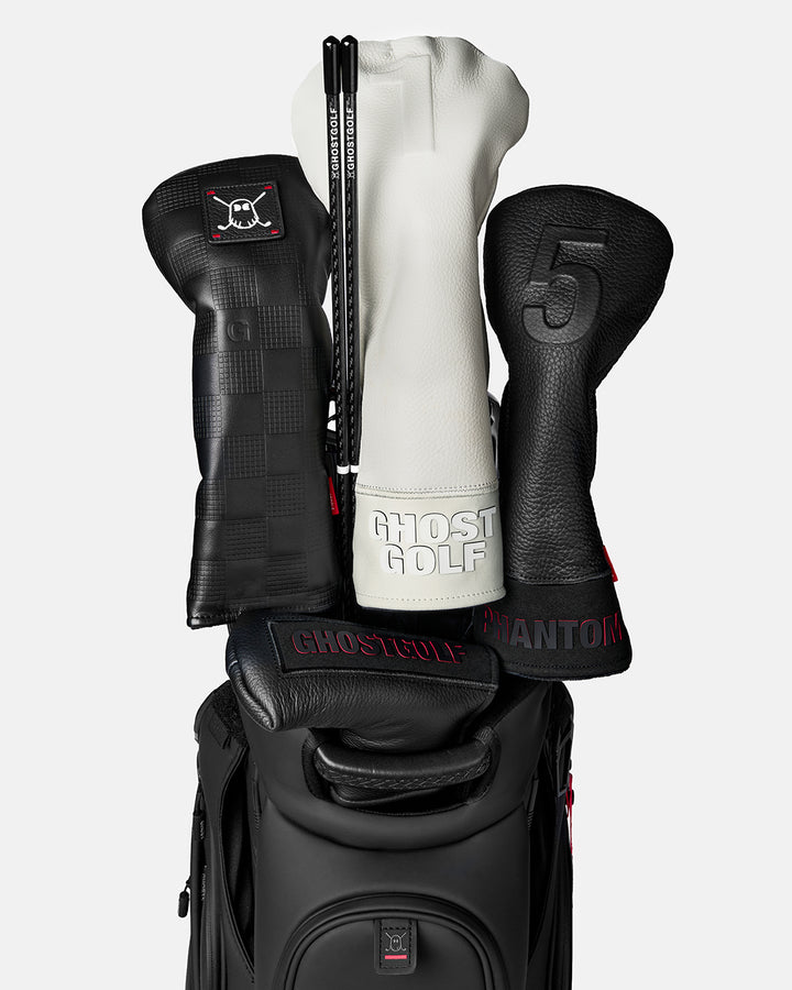 Front view of a Black Golf Alignment Stick stored in a golf bag beside several golf club head covers
#color_black