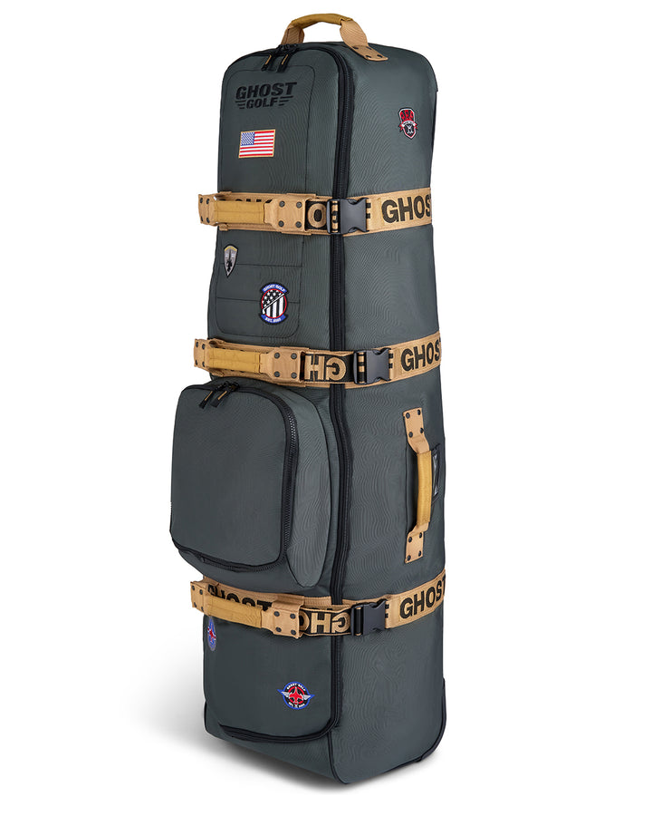 Three-quarter view of the G-Suit Primary AWOL Travel Bag showcasing Ghost Golf embroidery across the top panel, an embroidered USA flag detail, and custom military aviation-inspired patches throughout the bag. Angled product image highlighting the premium construction, travel-ready functionality, patriotic accents, unique badge details, and signature Ghost Golf craftsmanship. #color_green