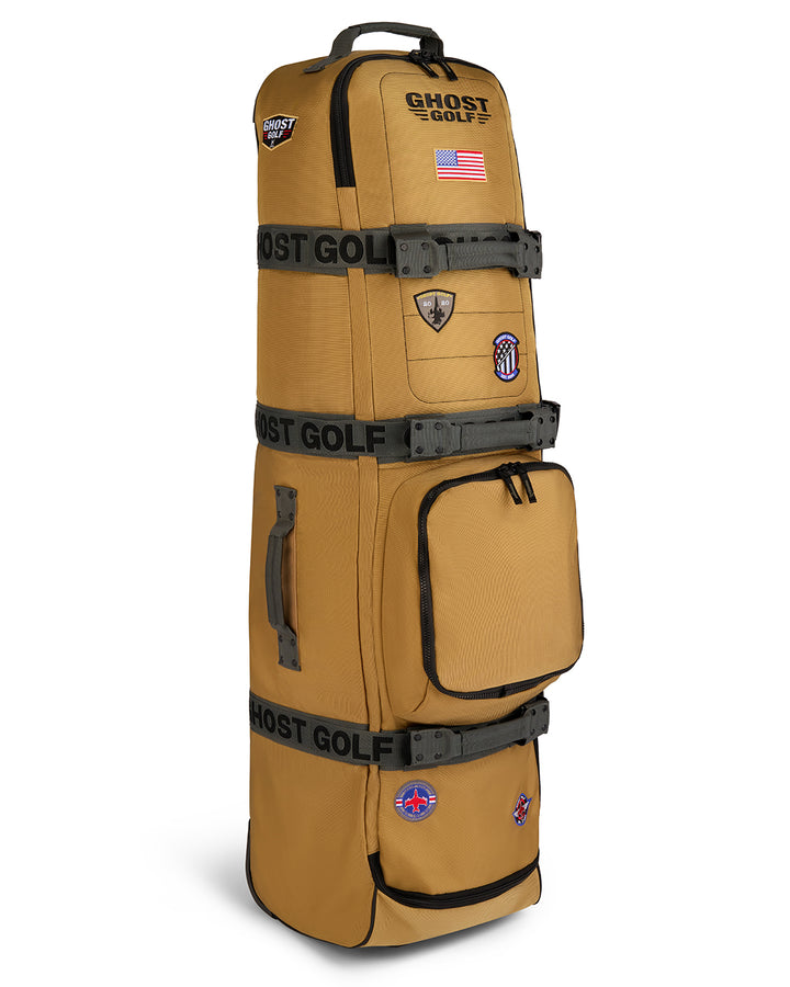 Three-quarter view of the G-Suit Secondary AWOL Travel Bag showcasing Ghost Golf embroidery across the top panel, an embroidered USA flag detail, and custom military aviation-inspired patches throughout the bag. Angled product image highlighting the premium construction, travel-ready functionality, patriotic accents, unique badge details, and signature Ghost Golf craftsmanship. #color_sand
