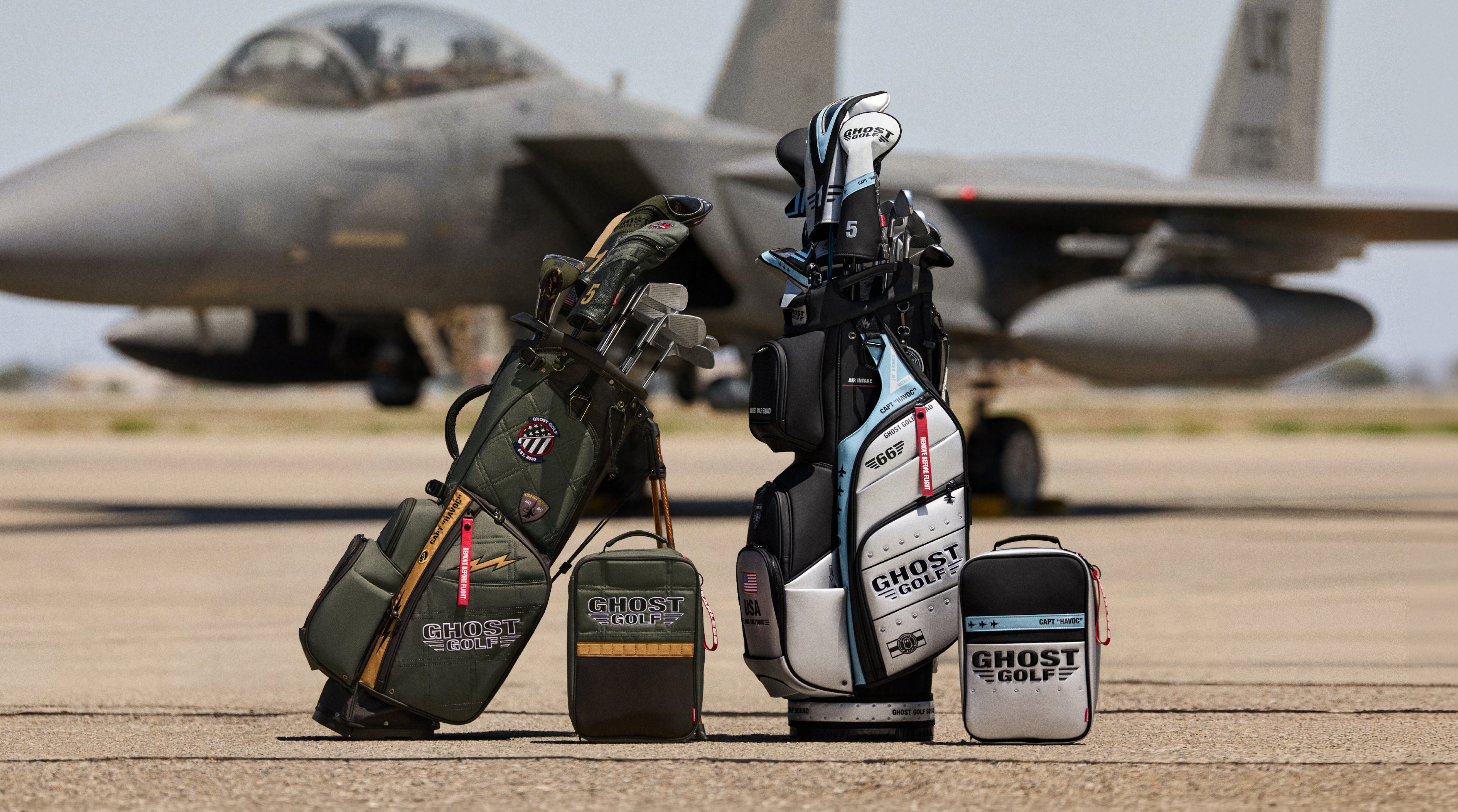 Lifestyle image featuring the G-Suit Anyday Bag, Striker GT-14 Cart Bag, and matching shoe bag displayed together. A blurred fighter jet appears in the background, creating an aviation-inspired setting that highlights the collection's travel-focused design and premium aesthetic.