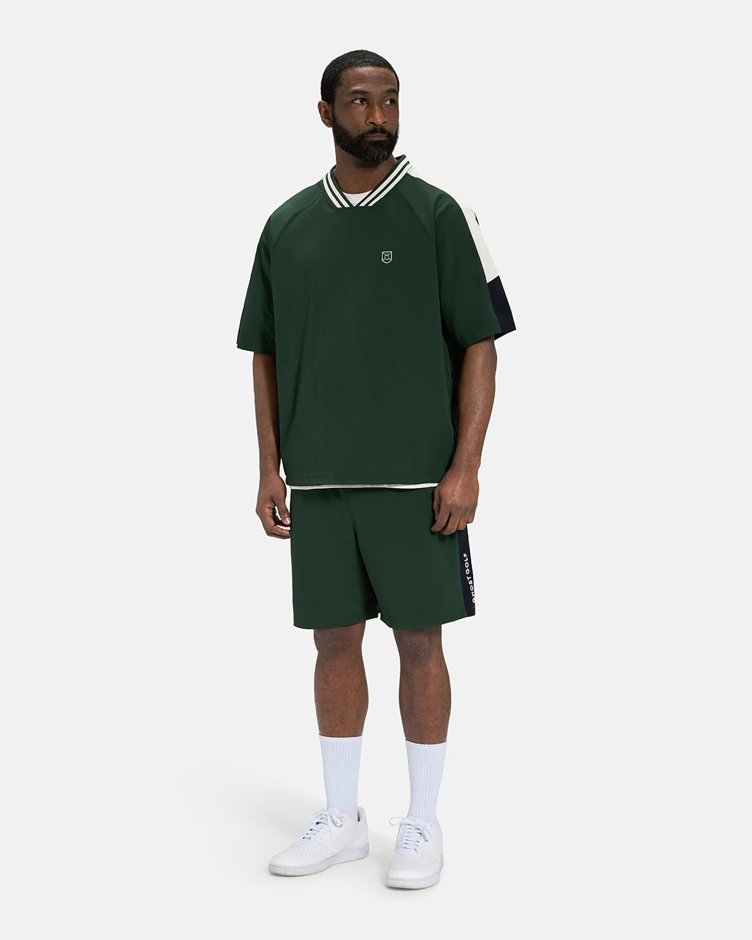 Full Body Front View of Bogey Green Fairway Windshirt V2 on Black Male Model wearing green shorts and white shoes #color_bogey-green
