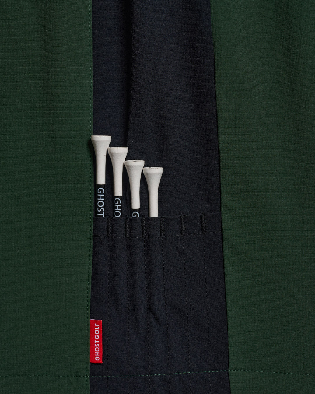 Detail Shot of Bogey Green Fairway Windshort V2 holding golf tees #color_bogey-green