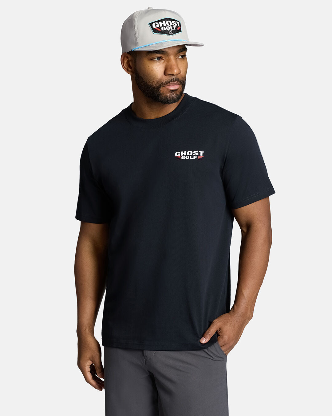 Black male model wearing Grey Flight Hat wearing a black t-shirt and black grey with hand in pocket looking towards his right #color_grey