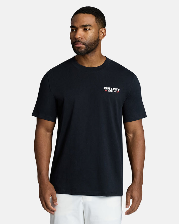 Top Front Body Shot of Black Male Model Wearing Black Flight Tee with white shorts. Ghost Golf Hit on the left front chest #color_black