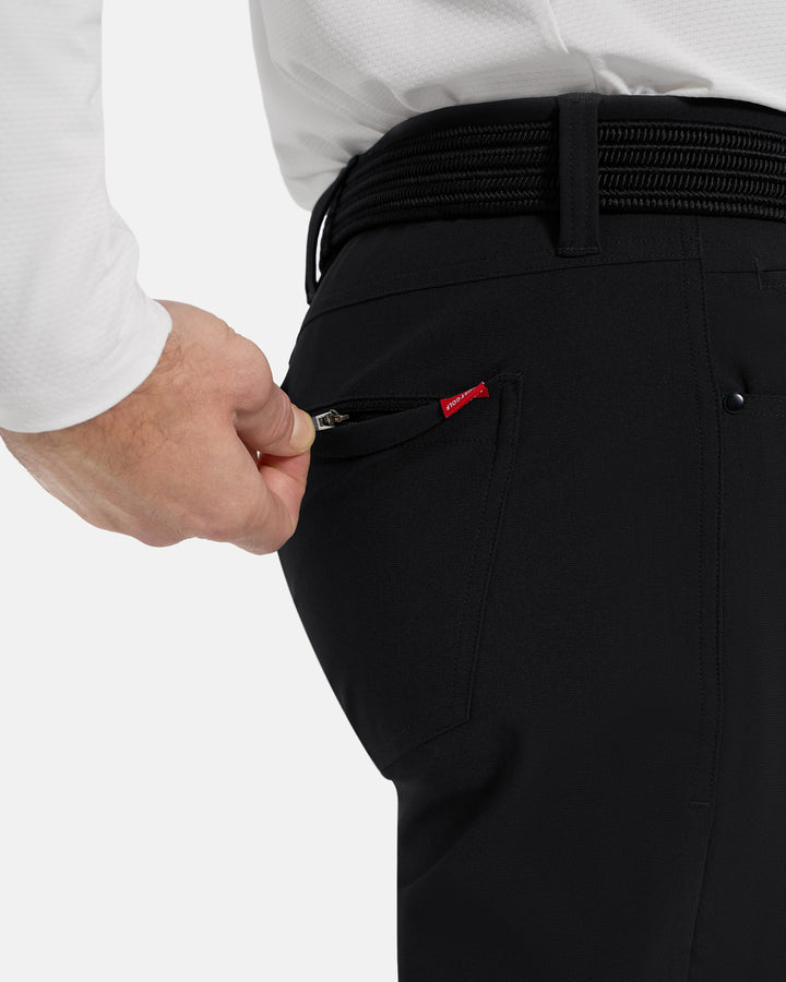Closeup Side View of Black Ghost Golf Core 5 Pocket Pant on White Male Model with hand pulling back pocket zipper #color_black