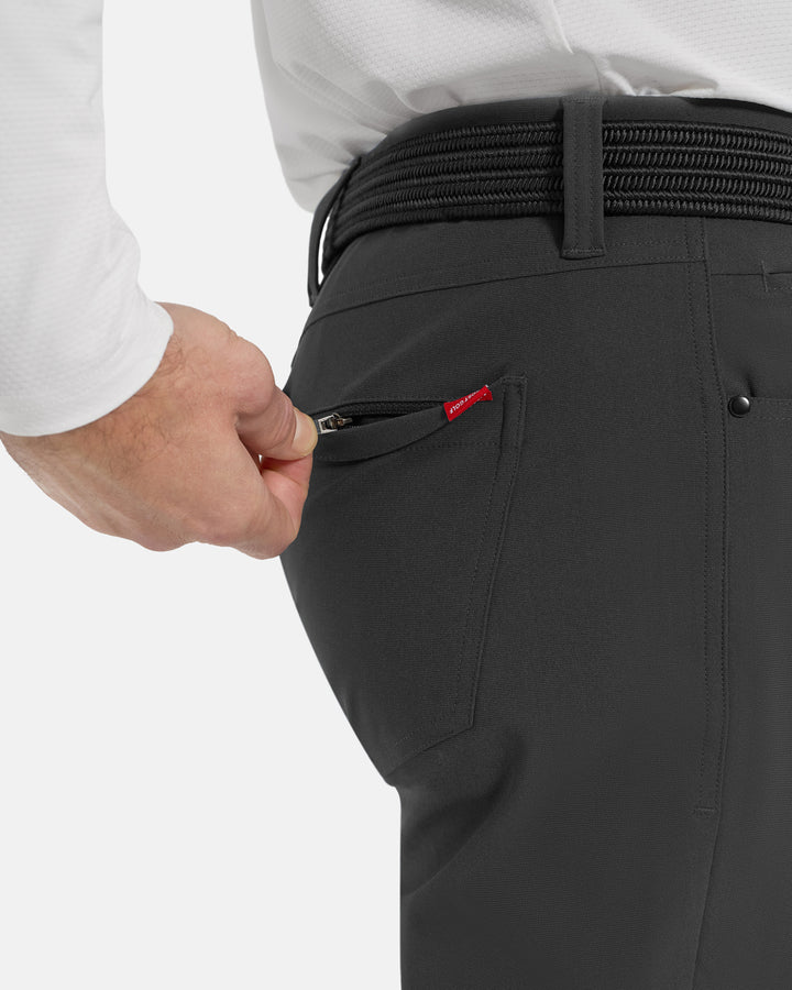 Closeup Side View of Iron Grey Ghost Golf Core 5 Pocket Pant on White Male Model with hand pulling back pocket zipper #color_iron-grey