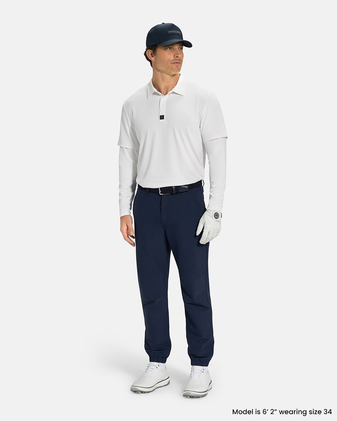 Full Body Front View of Navy Ghost Golf Core Jogger Pant on White Male Model wearing white polo navy belt navy hat  white glove and white shoes #color_navy