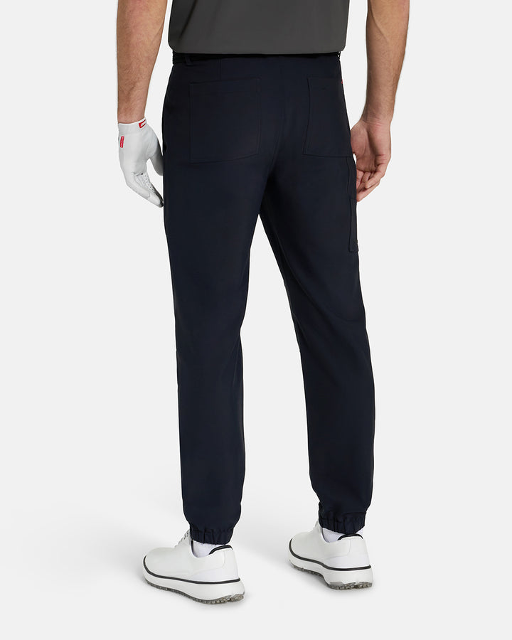 Back View of Black Ghost Golf Core Jogger Pant on White Male Model with White Shoes #color_black