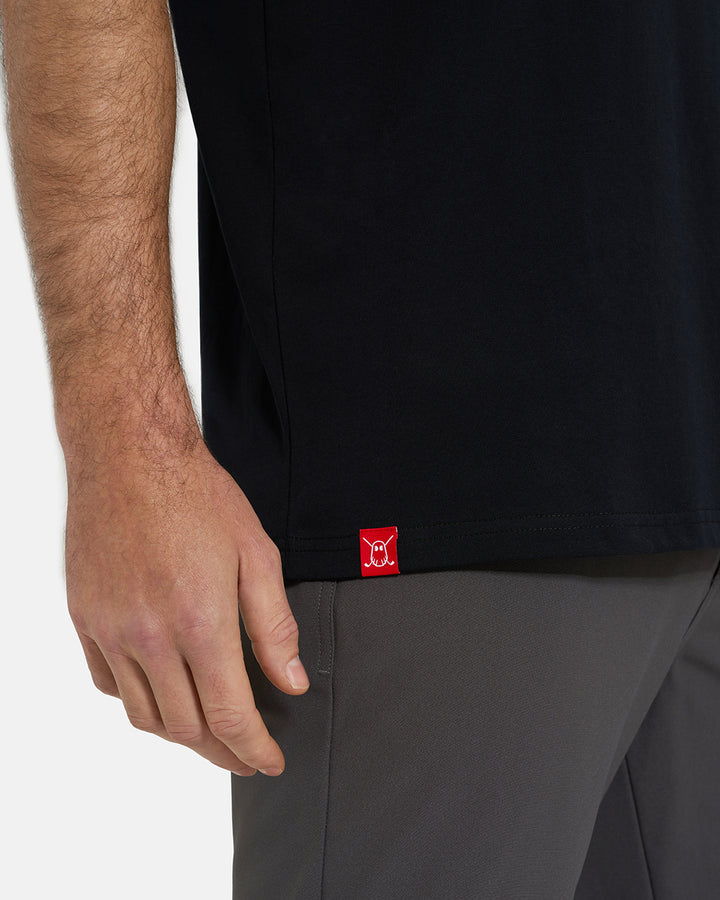 Bottom Closeup View of Black Ghost Golf Core Logo Tee on White Male Model with Ghost Icon Hit #color_black
