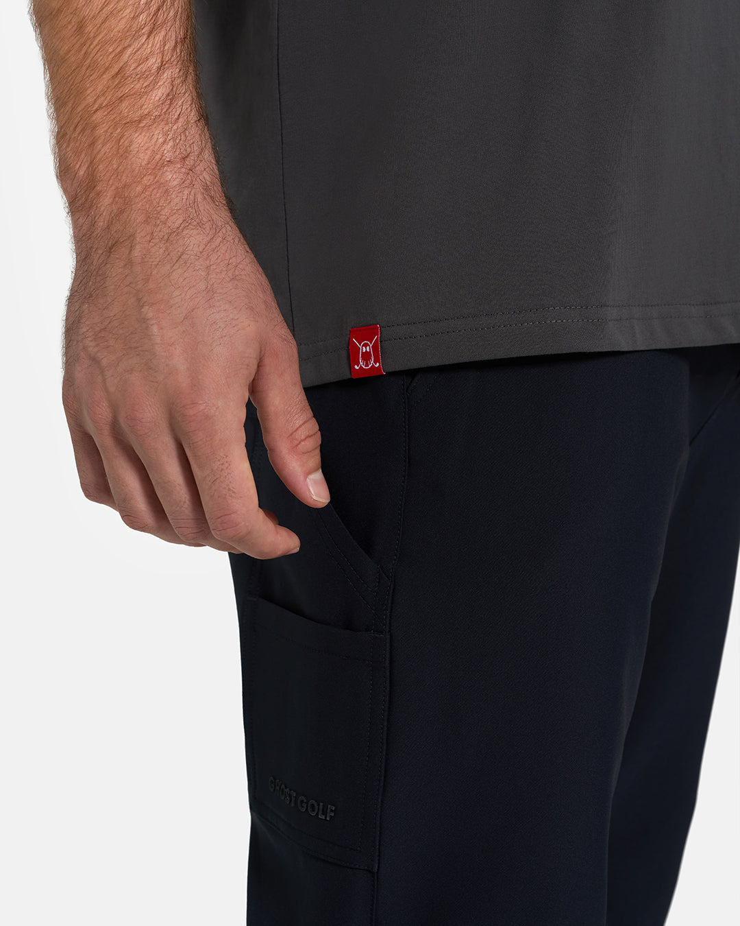 Bottom Closeup View of Iron Grey Ghost Golf Core Logo Tee on White Male Model with Ghost Icon Hit #color_iron-grey