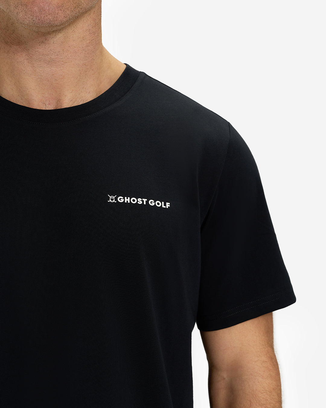 Front Closeup View of Black Ghost Golf Core Logo Tee on White Male Model #color_black