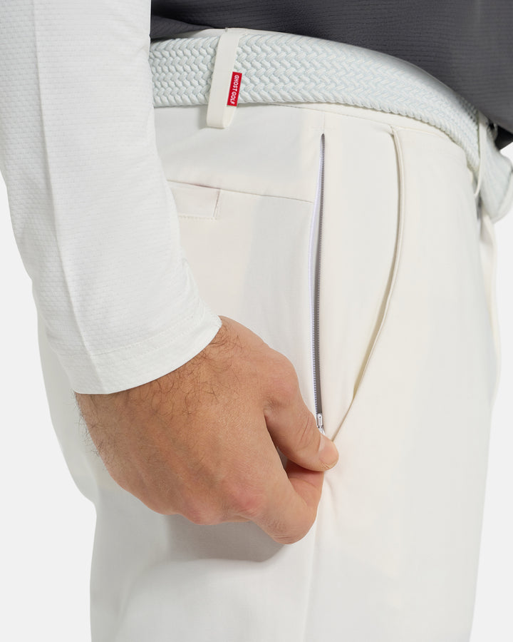 Closeup Side View of White Ghost Golf Core Pant on White Male Model pulling down side zipper #color_white