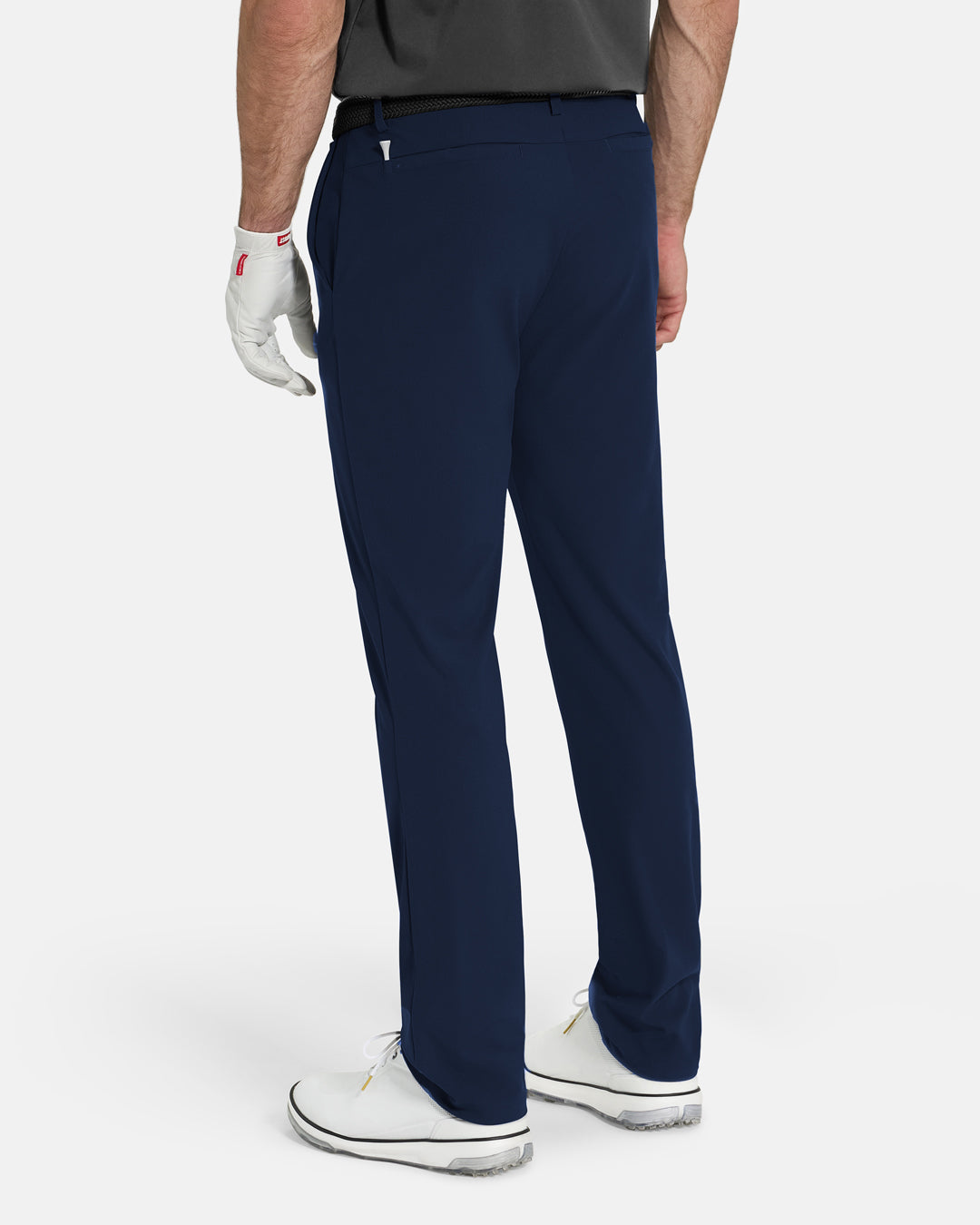 Back View of Navy Ghost Golf Core Pant on White Male Model with white shoes #color_navy