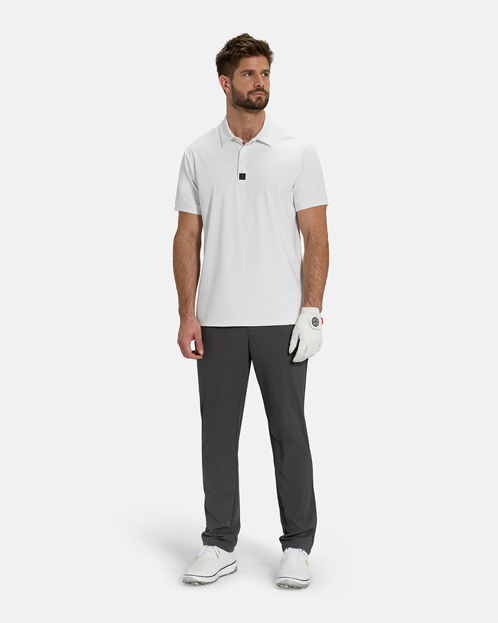 Full Body View of Optic White Ghost Golf Core Polo Untucked on White Male Model wearing grey pants white gloves and white shoes #color_white