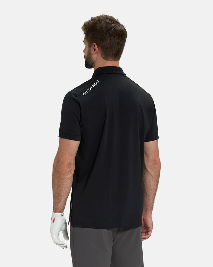 Back View of Black Ghost Golf Core Polo Untucked on White Male Model with Ghost Golf logo on back #color_black