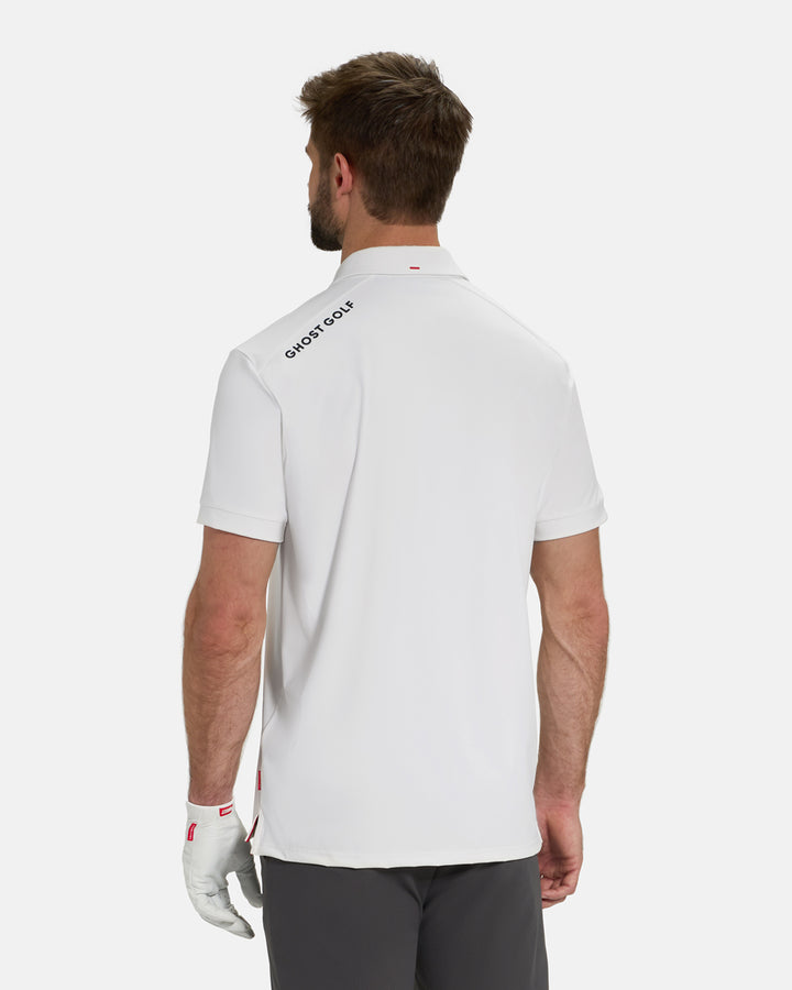 Back View of Optic White Ghost Golf Core Polo Untucked on White Male Model with Ghost Golf logo on back #color_white