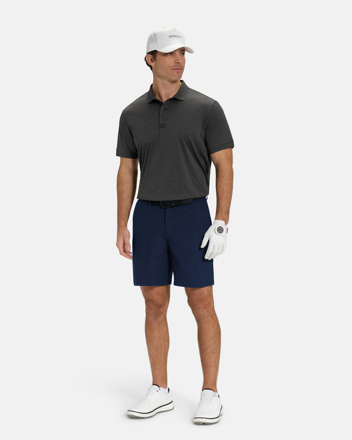 Full Body Front View of Navy Ghost Golf Core Short on White Male Model wearing grey polo black belt white hat white glove and white shoes #color_navy