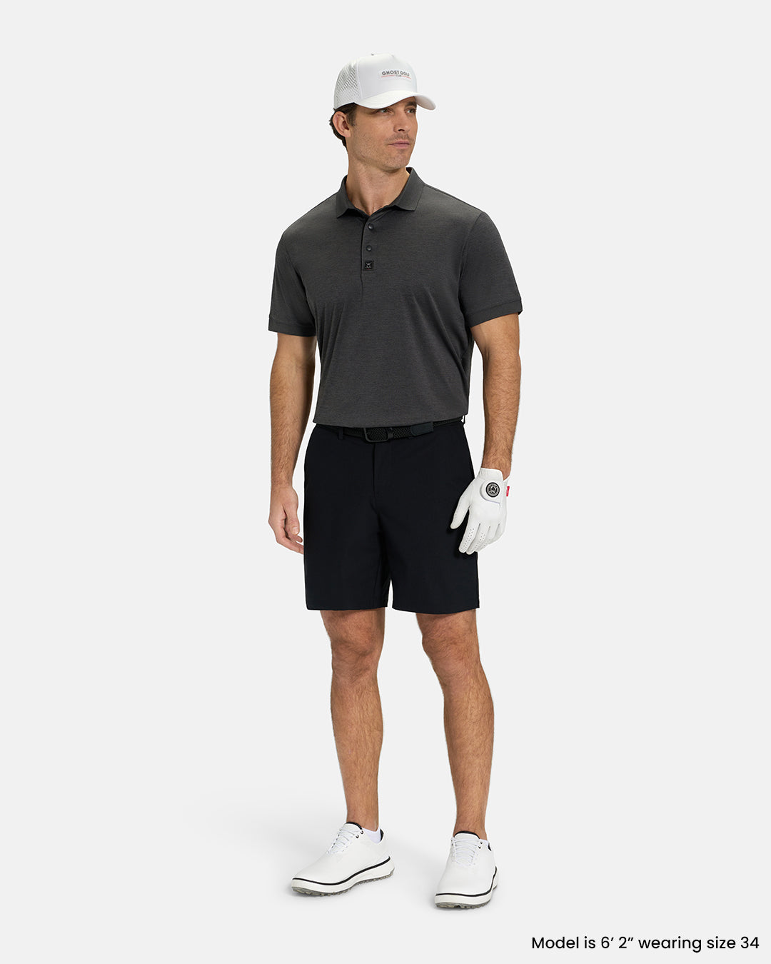 Full Body View of Black Ghost Golf Core Short on White Male Model wearing grey polo white gloves black belt white shoes and white hat #color_black
