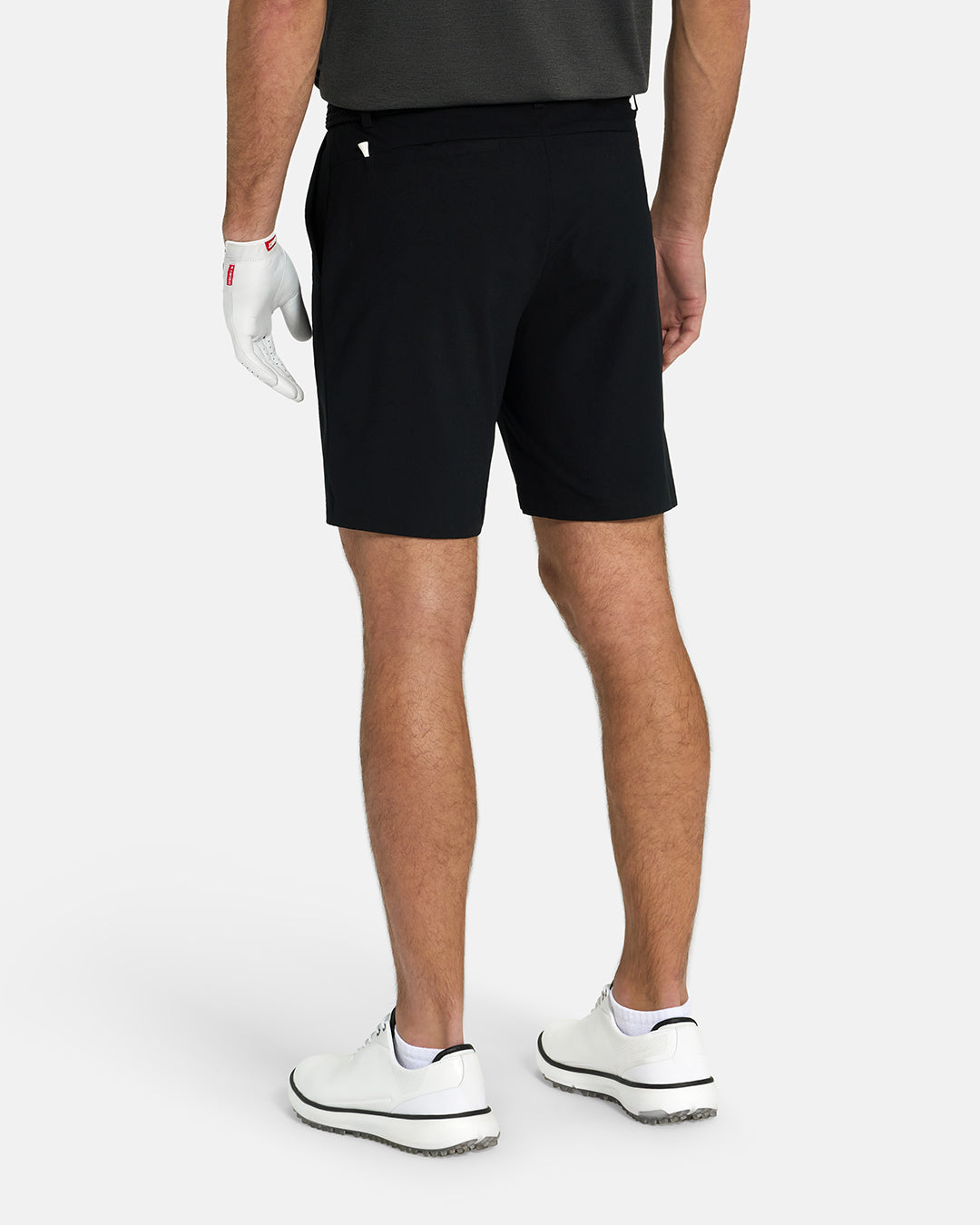 Back View of Black Ghost Golf Core Short on White Male Model with White Shoes #color_black
