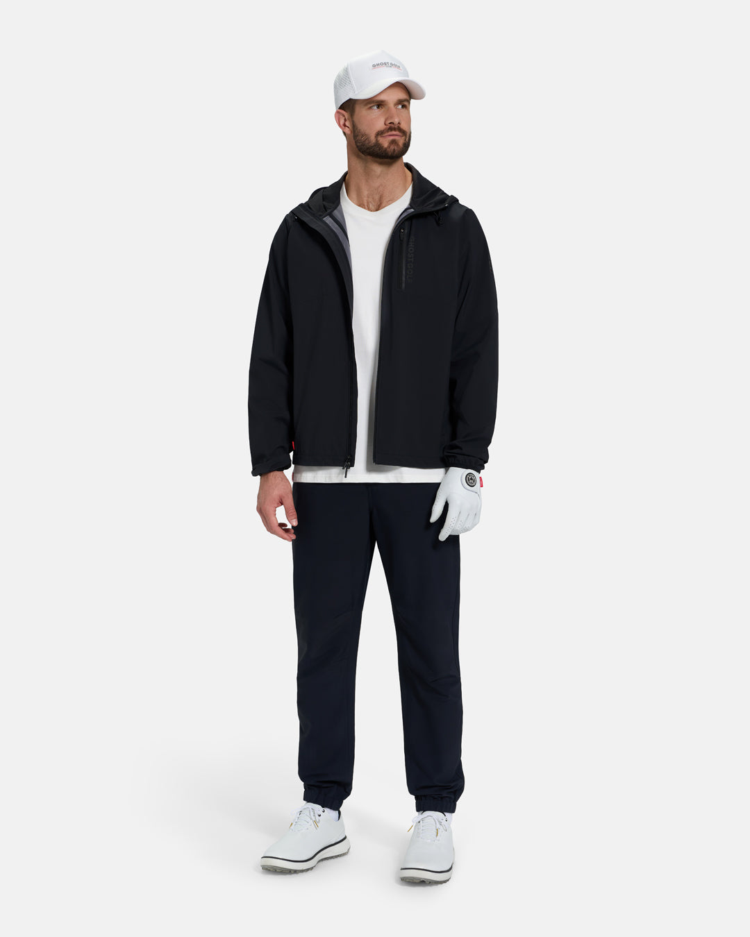 Full Body Front View of Black Ghost Golf Hooded Zip Shell Jacket on White Male Model wearing white tee white white glove white hat white shoes and black pants #color_black