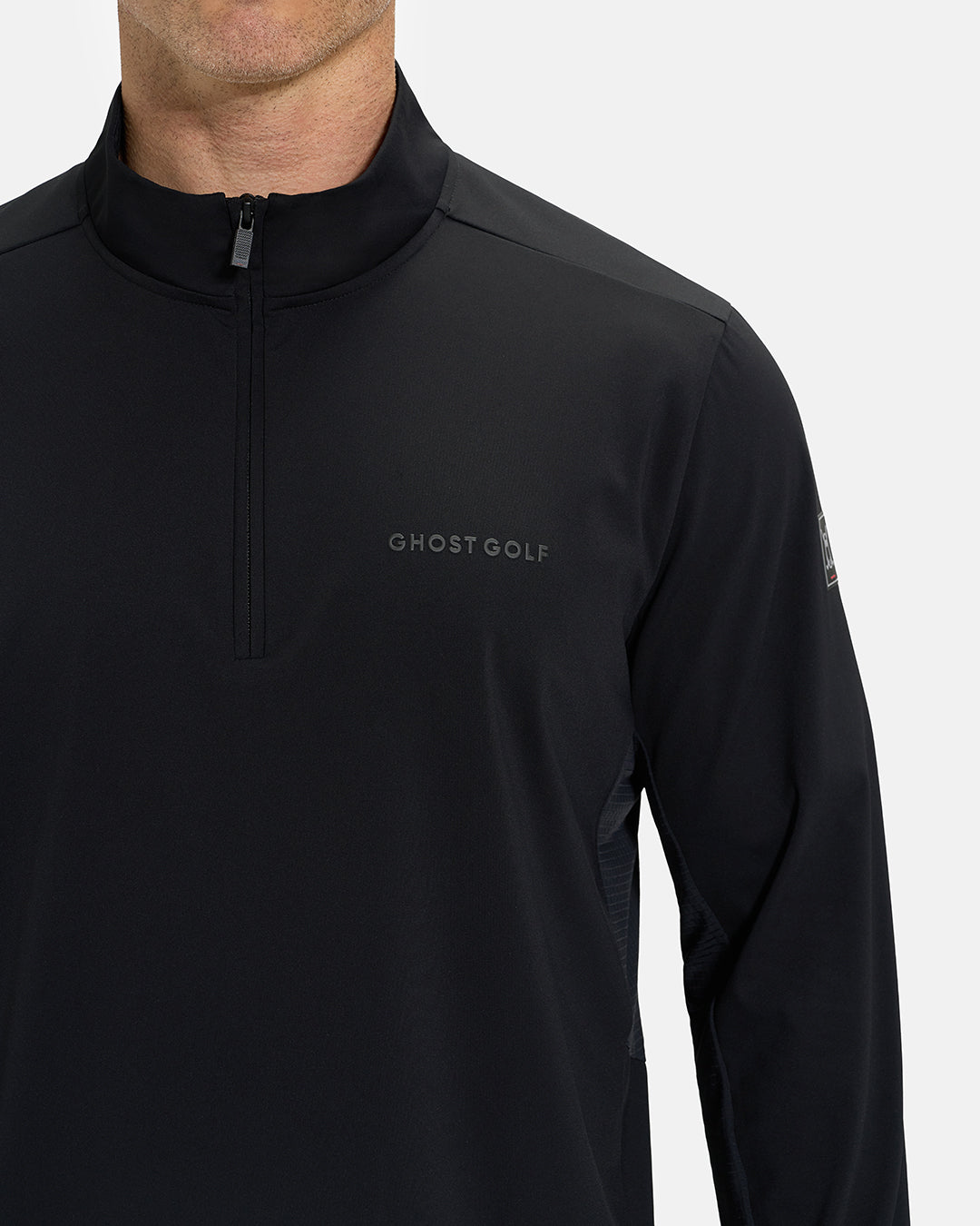 Front Closeup View of Black Ghost Golf Quarter Zip Mock Jacket with Ghost Golf Logo on White Male Model #color_black