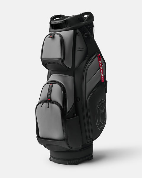 GHOSTGOLF GT-14 KOvert Ops golf bag in black and grey, shown at a three-quarter angle with zippered pockets, an embossed Ghost Golf logo, and a red “Play Fearlessly” tag.