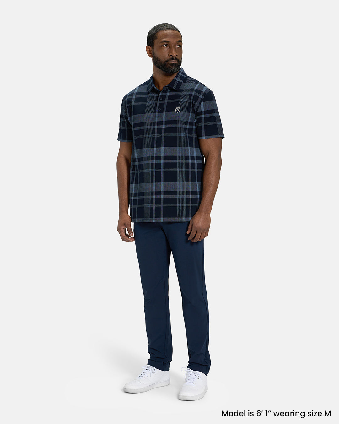 Full Body Front View of Navy Spectator Plaid Polo on Black Male Model wearing navy pants and white shoes #color_navy