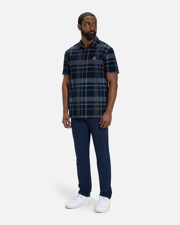 Full Body Front View of Navy Spectator Plaid Polo on Black Male Model wearing navy pants and white shoes #color_navy