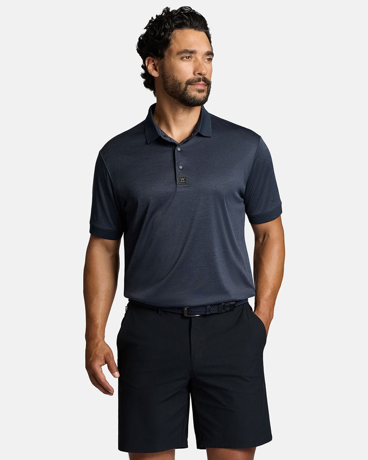 Top Front Body Shot of White Male Model Wearing Dark Navy Marled Core Polo with navy shorts and navy belt #color_dark-navy