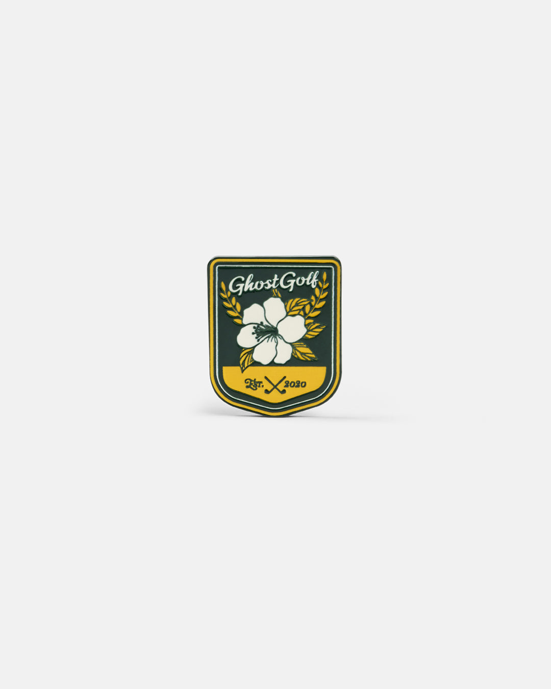 Product photo of a shield-shaped ball marker featuring a green and yellow color scheme with the Ghost Golf logo, an azalea design.
