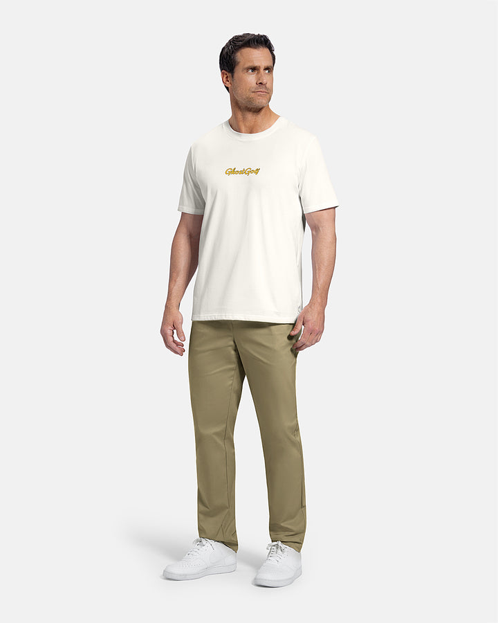 Full Body Front View of White Patrons Azalea Badge Tee on white male model wearing beige pants and white shoes #color_white