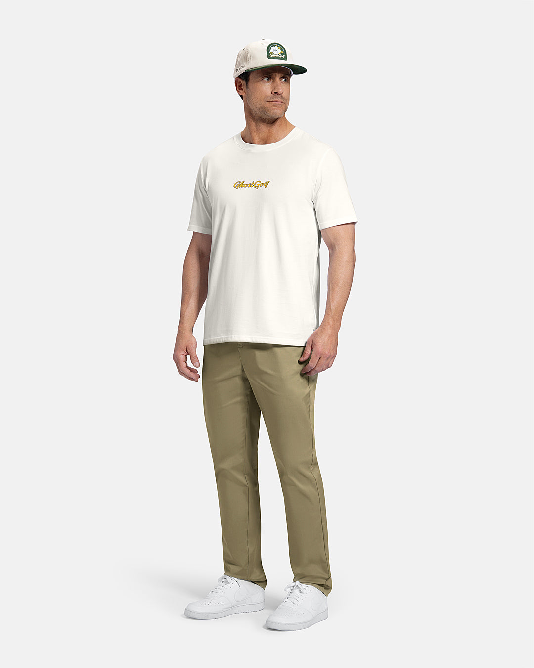 Full Body Front View of White Patrons Azalea Badge Tee on white male model wearing beige pants and white shoes and hat #color_white