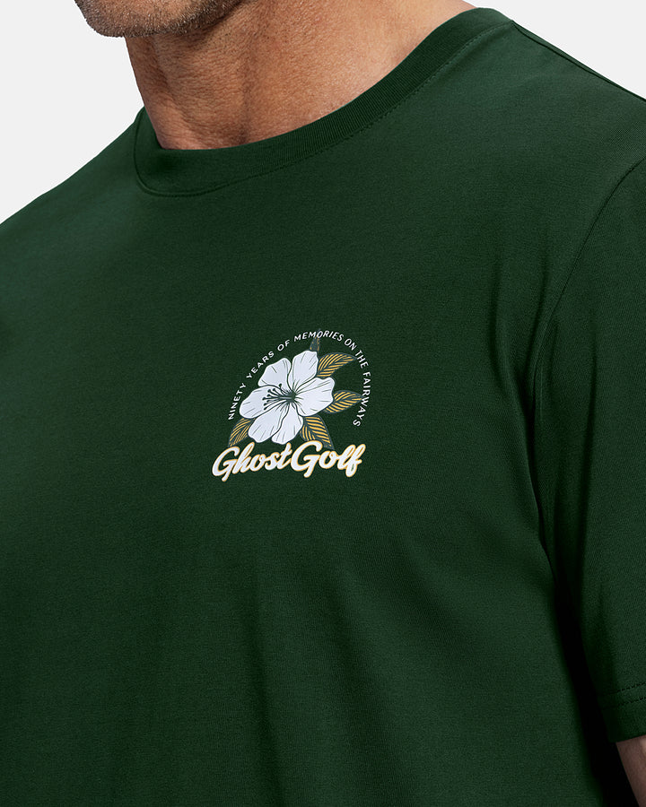 Closeup Front View of White Patrons Azalea Tee on white male model showing ghost golf graphic hit #color_bogey-green