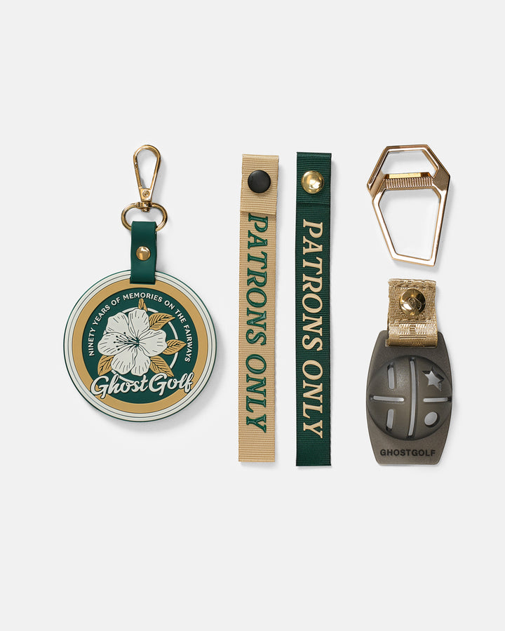 Product Shot of Golf Bag Accessories including ghost golf badge keychain carabiner and 2 patrons only pull tags and ball marker 