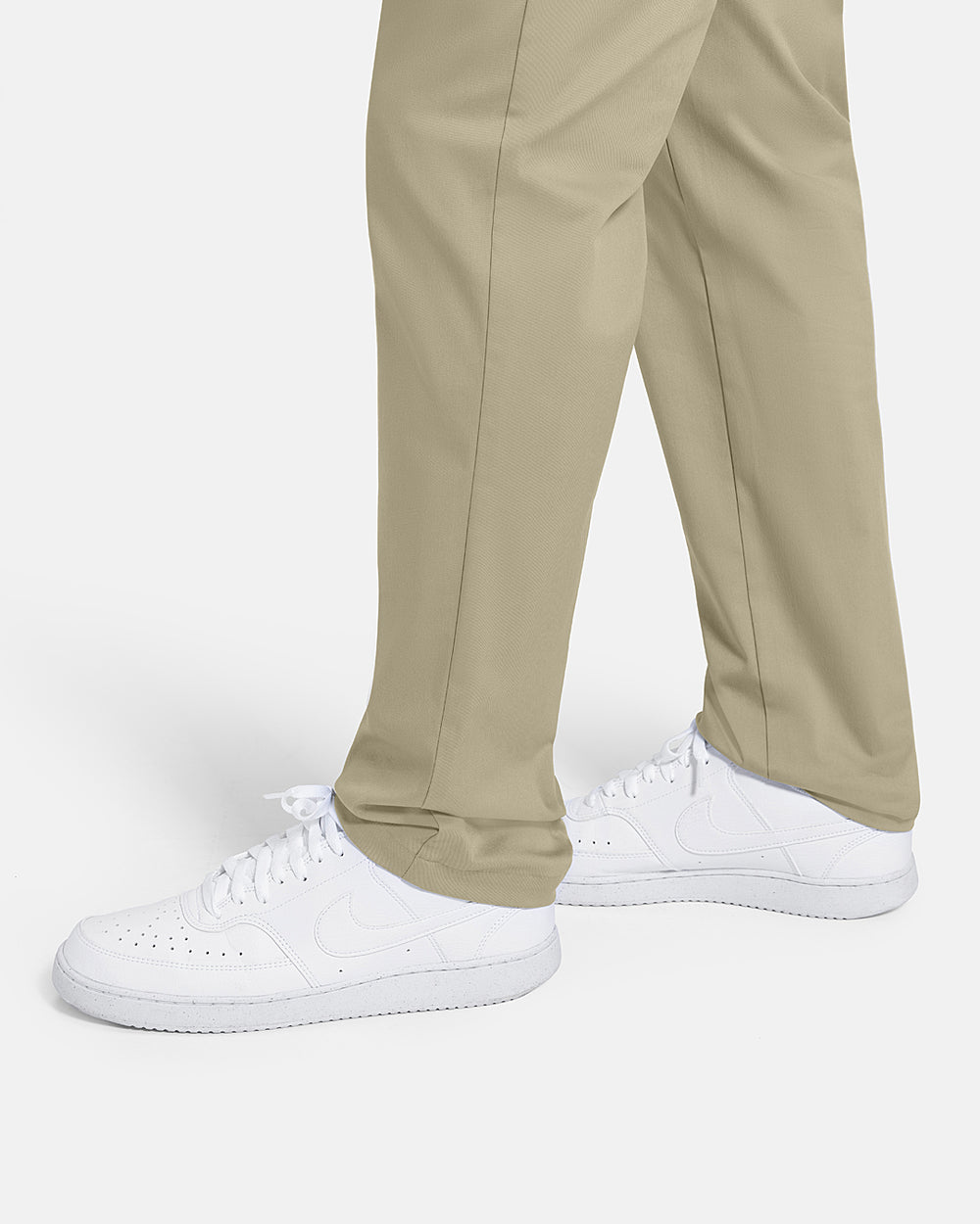 Closeup Side View of Sand Patrons Pleated Pant on white male model wearing white shoes #color_sand