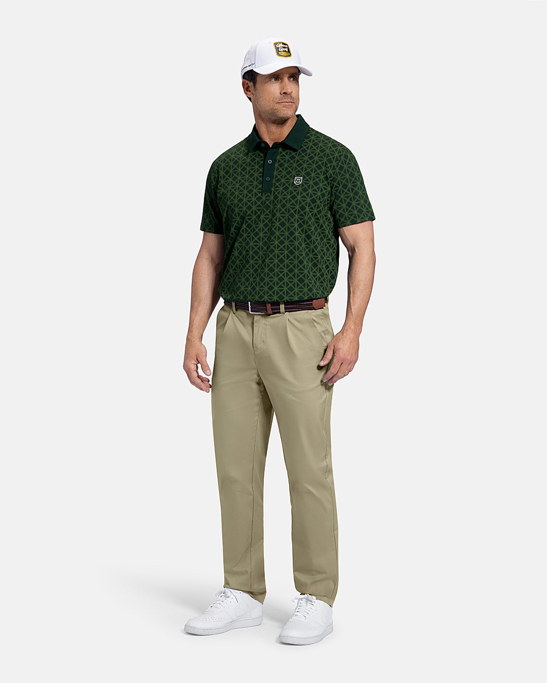 Full Body Front View of Sand Patrons Pleated Pant on white male model wearing green polo brown belt  and white shoes and hat with polo tucked in pants #color_sand
