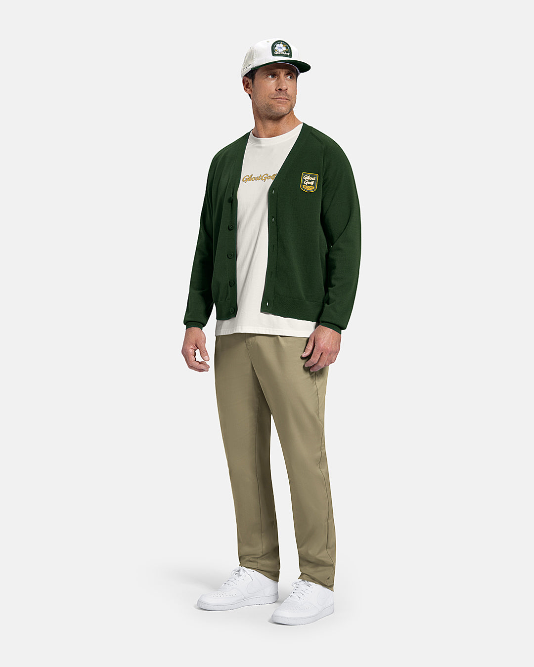 Full Body Front View of Bogey Green Patrons Sweater Cardigan on white male model wearing beige pants and white shoes and white tee and hat #color_bogey-green