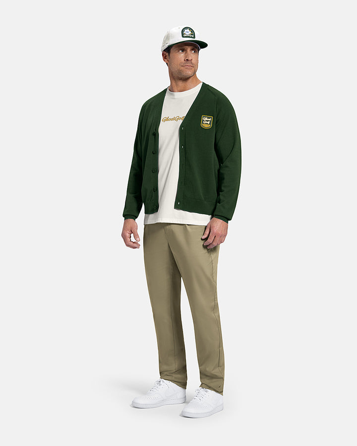 Full Body Front View of Bogey Green Patrons Sweater Cardigan on white male model wearing beige pants and white shoes and white tee and hat #color_bogey-green