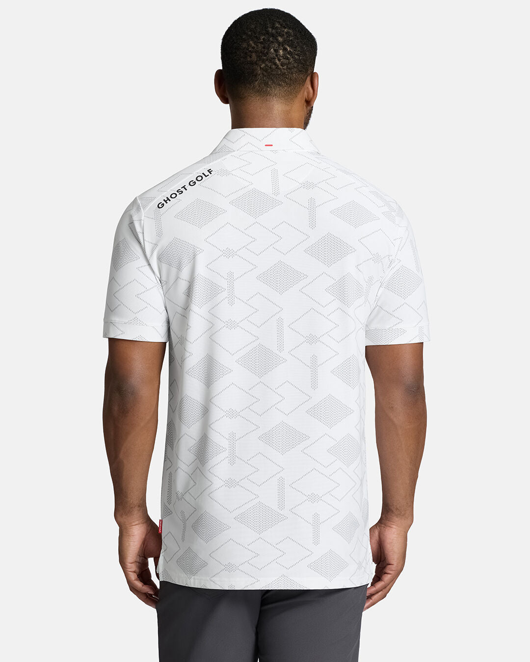 Top Back Body Shot of Black Male Model Wearing White Qualifier Argyle Polo with grey pants. Ghost Golf Hit on back left shoulder #color_white
