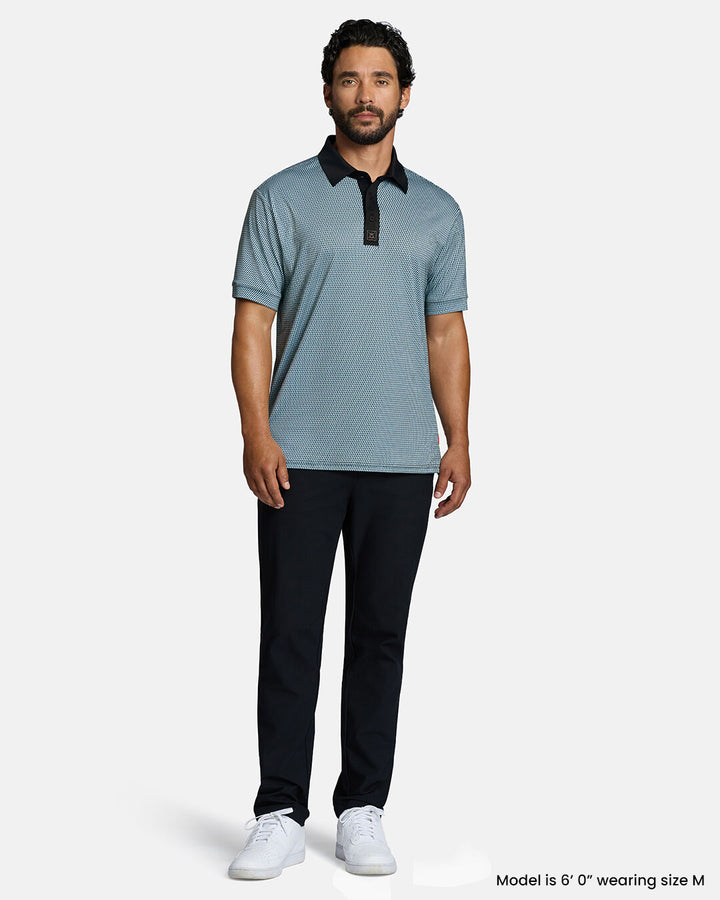 Full Body Front Shot of White Male Model Wearing Blue Qualifier Diamond Polo with black pants and white shoes. Polo is untucked. #color_blue