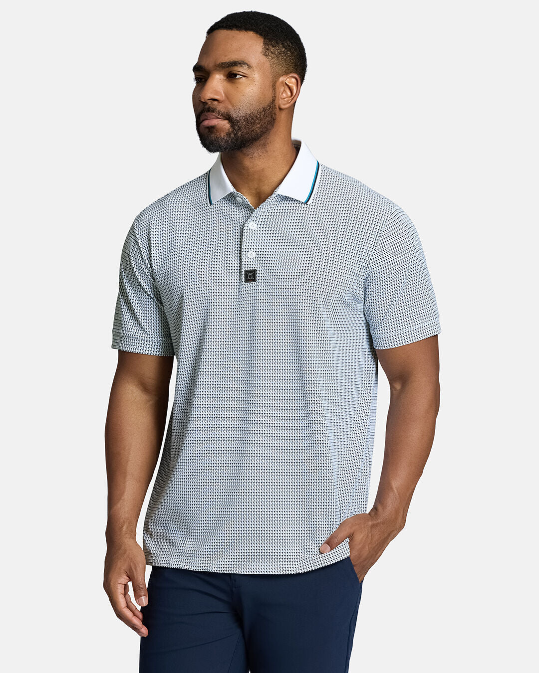 Top Body Front Shot of Black Male Model Wearing White Qualifier Flag Polo with navy pants with hand in pocket. Polo is untucked #color_white