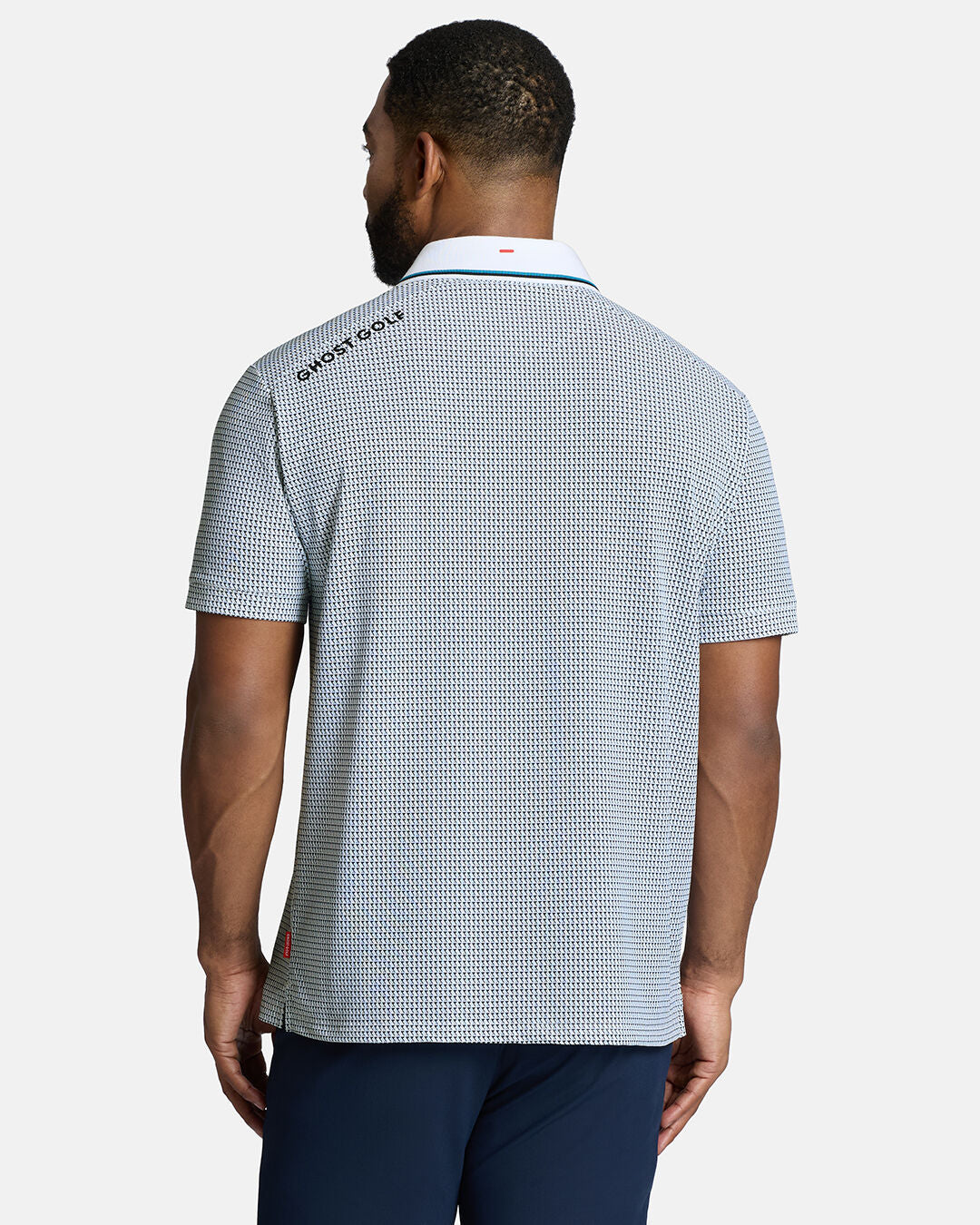 Top Back Body Shot of Black Male Model Wearing White Qualifier Flag Polo with navy pants. Ghost Golf Hit on back left shoulder #color_white