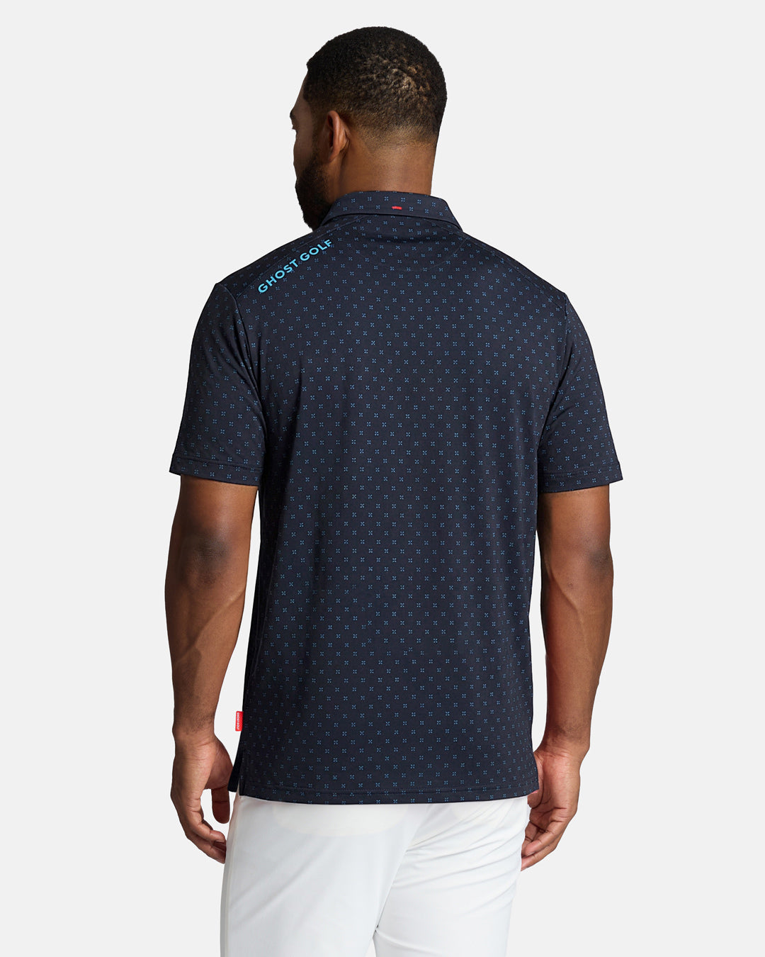 Top Back Body Shot of Black Male Model Wearing Grey Qualifier Geo Polo with white pants. Ghost Golf Hit on back left shoulder #color_navy