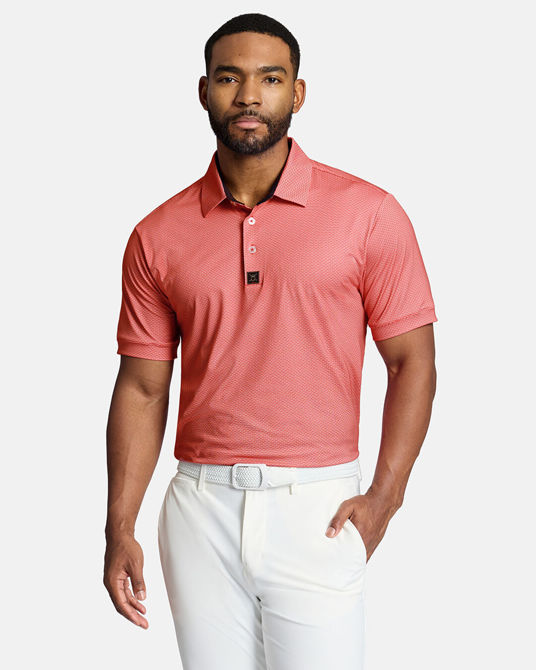 Top Front Shot of Black Male Model Wearing Red Qualifier Grid Polo tucked in white pants wearing white belt. #color_red