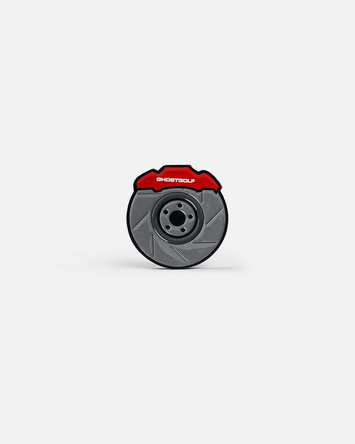 Product photo of a ball marker featuring a brake disc design with “Ghost Golf” displayed at the top of the disc.