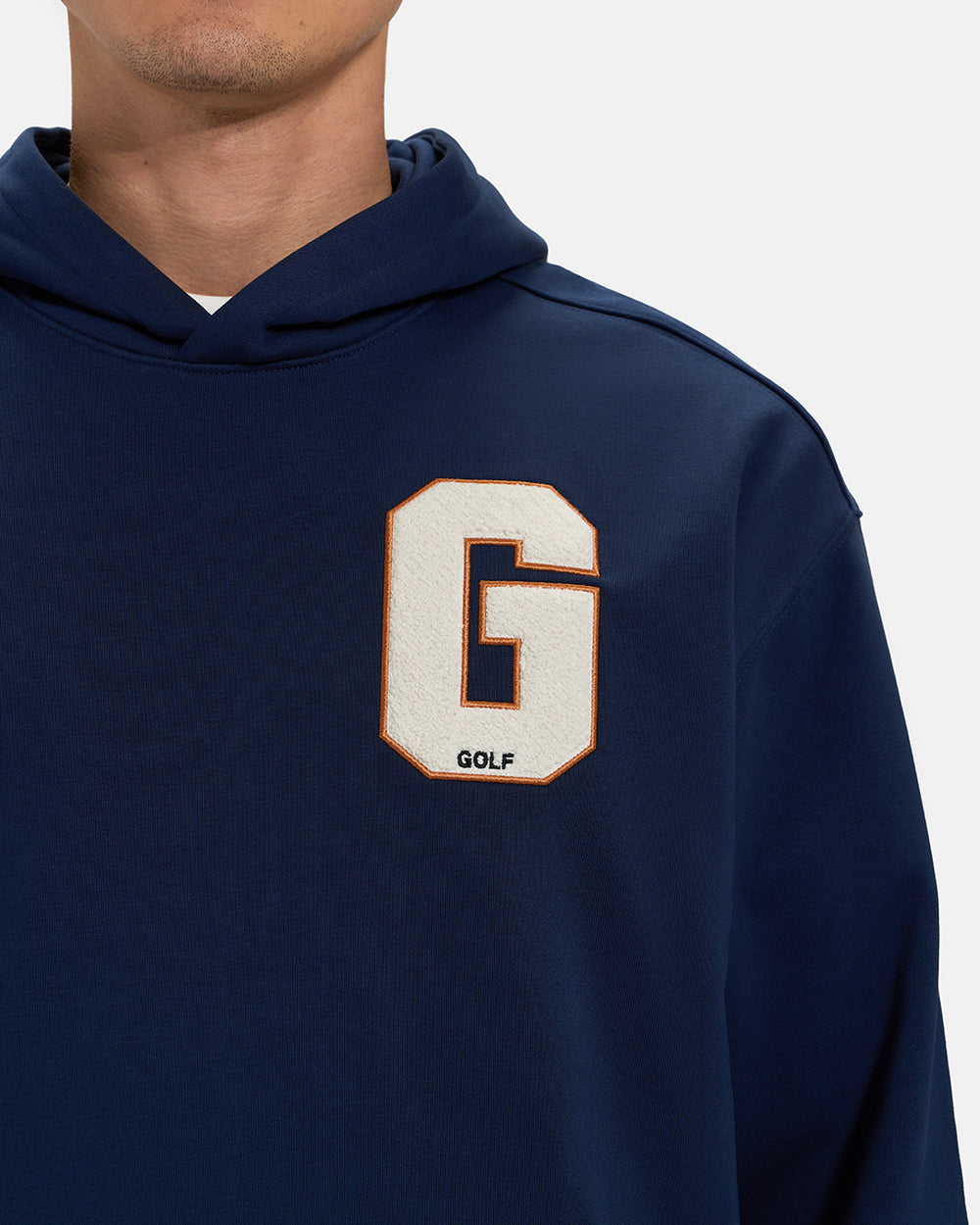 Front Closeup View of Navy Spectator Hoodie on Asian Male Model with letter G chest Hit  #color_navy