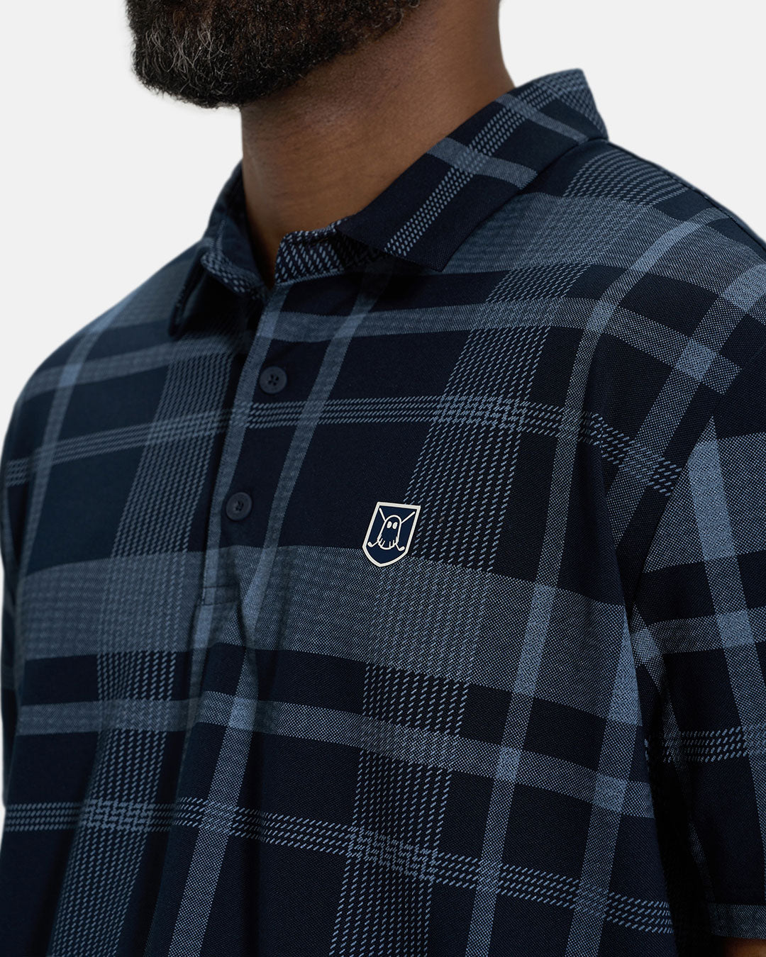 Front Closeup View of Navy Spectator Plaid Polo on Black Male Model with Ghost Icon Crest #color_navy